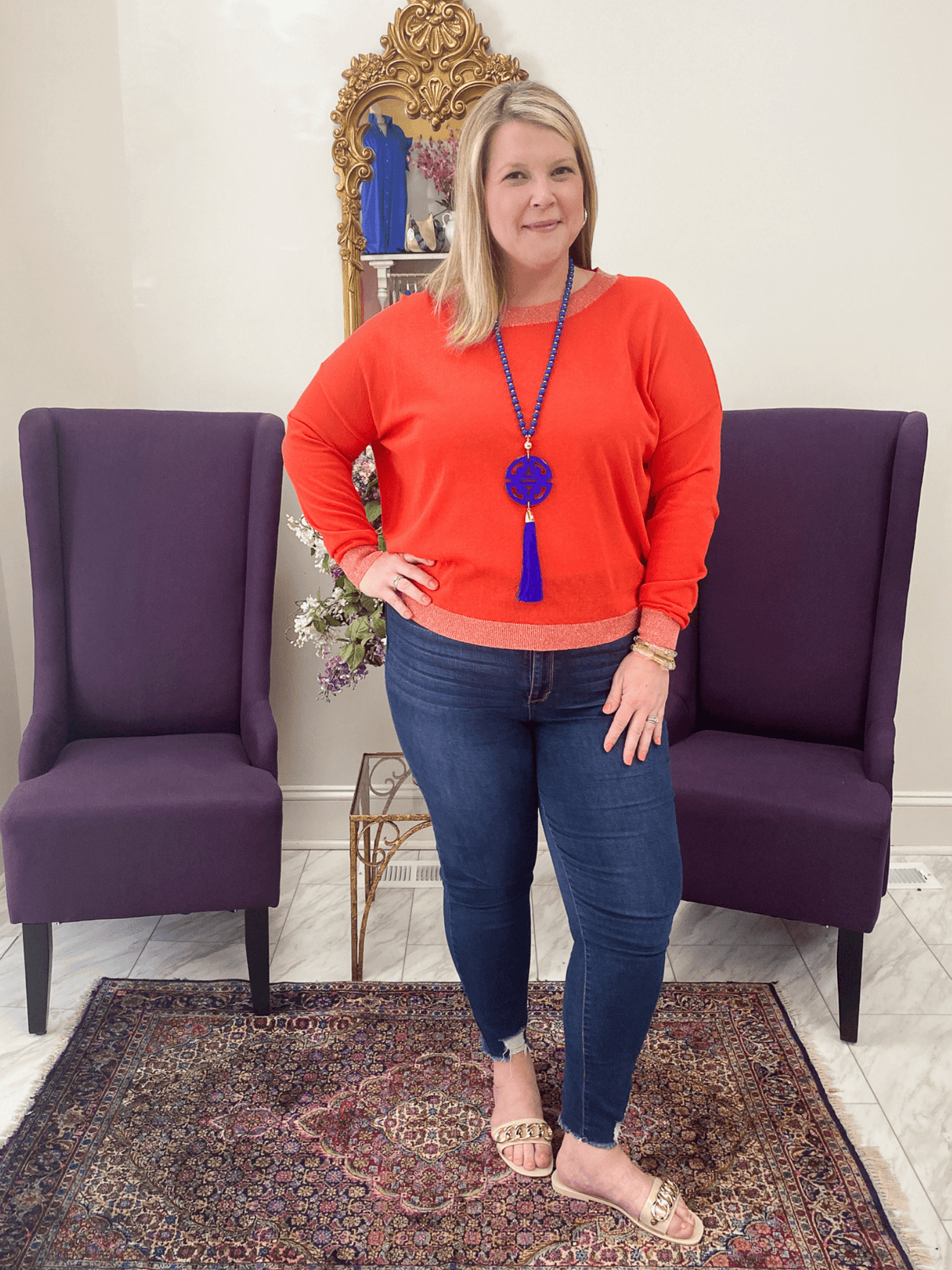 red-orange sweater with gold sparkly detailed hemlines on a curvy model