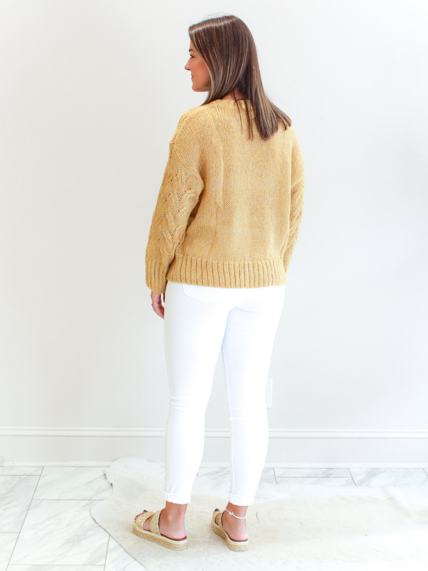 Gold Cable Knit Sweater back view with white jeans.