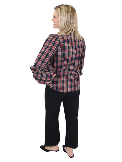 Woman wearing a plaid shirt and black pants on a white background