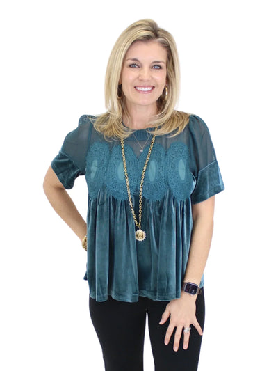 Woman wearing a teal blouse with a white background
