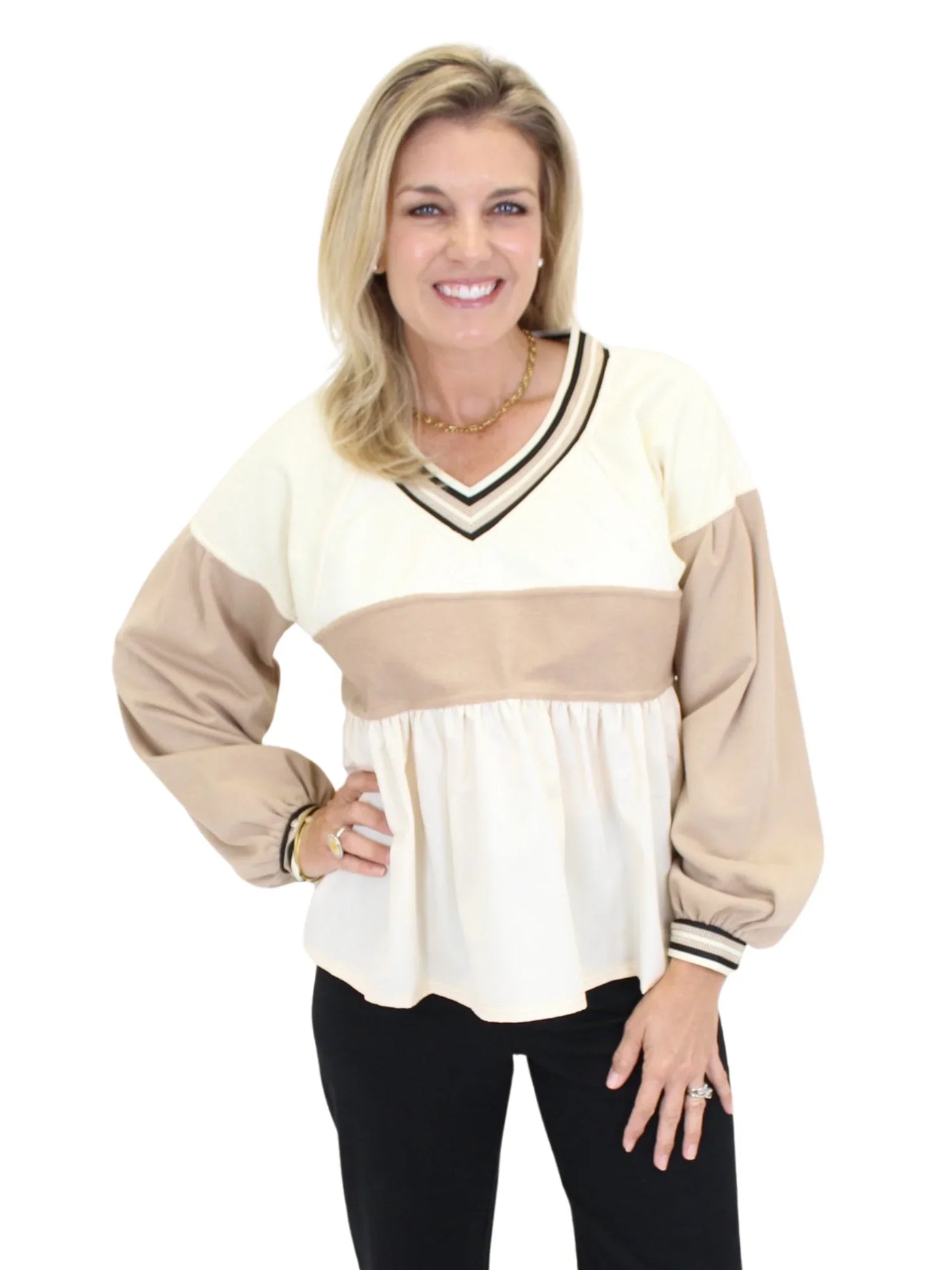 Woman wearing a cream and beige long-sleeve top on a white background