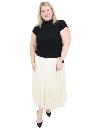 Woman wearing a black top and white skirt on a white background