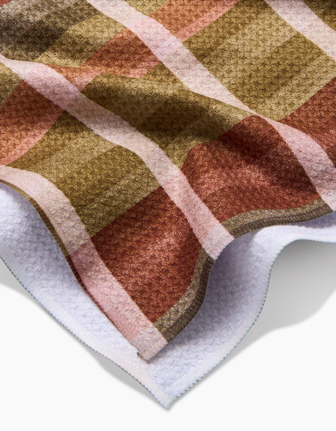Closeup of a plaid tea towel with autumnal colors on white background