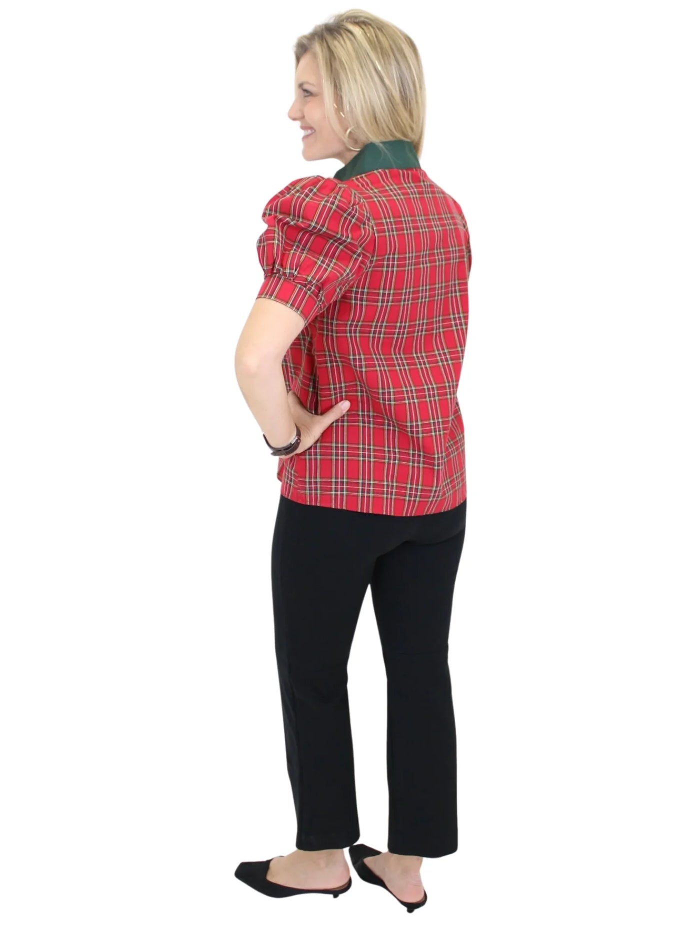 Woman wearing a red plaid shirt and black pants on a white background