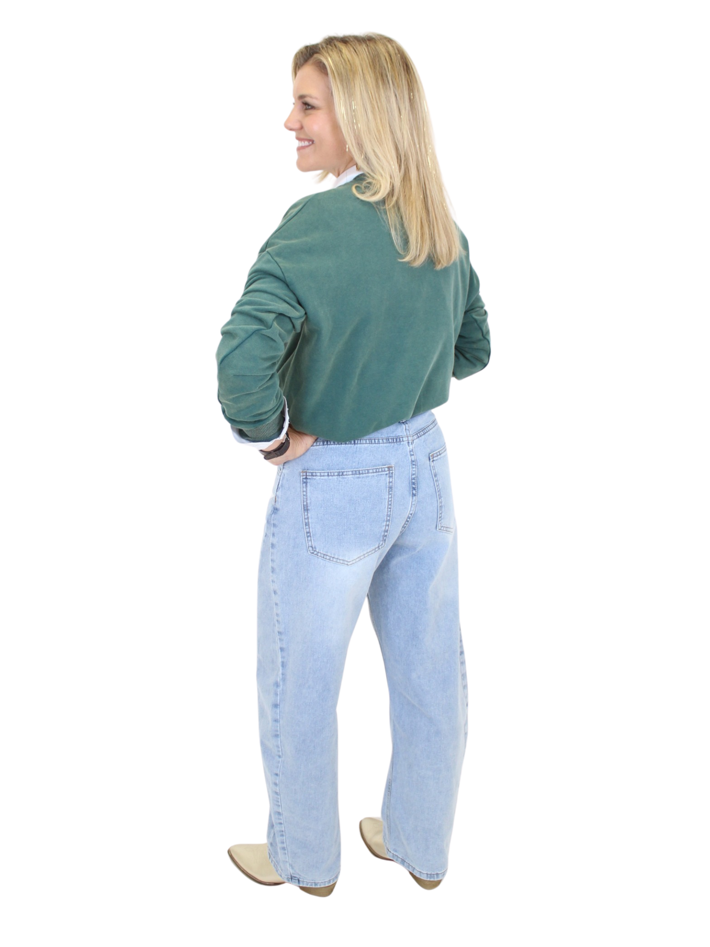 Woman wearing a green sweater and light blue jeans on a white background