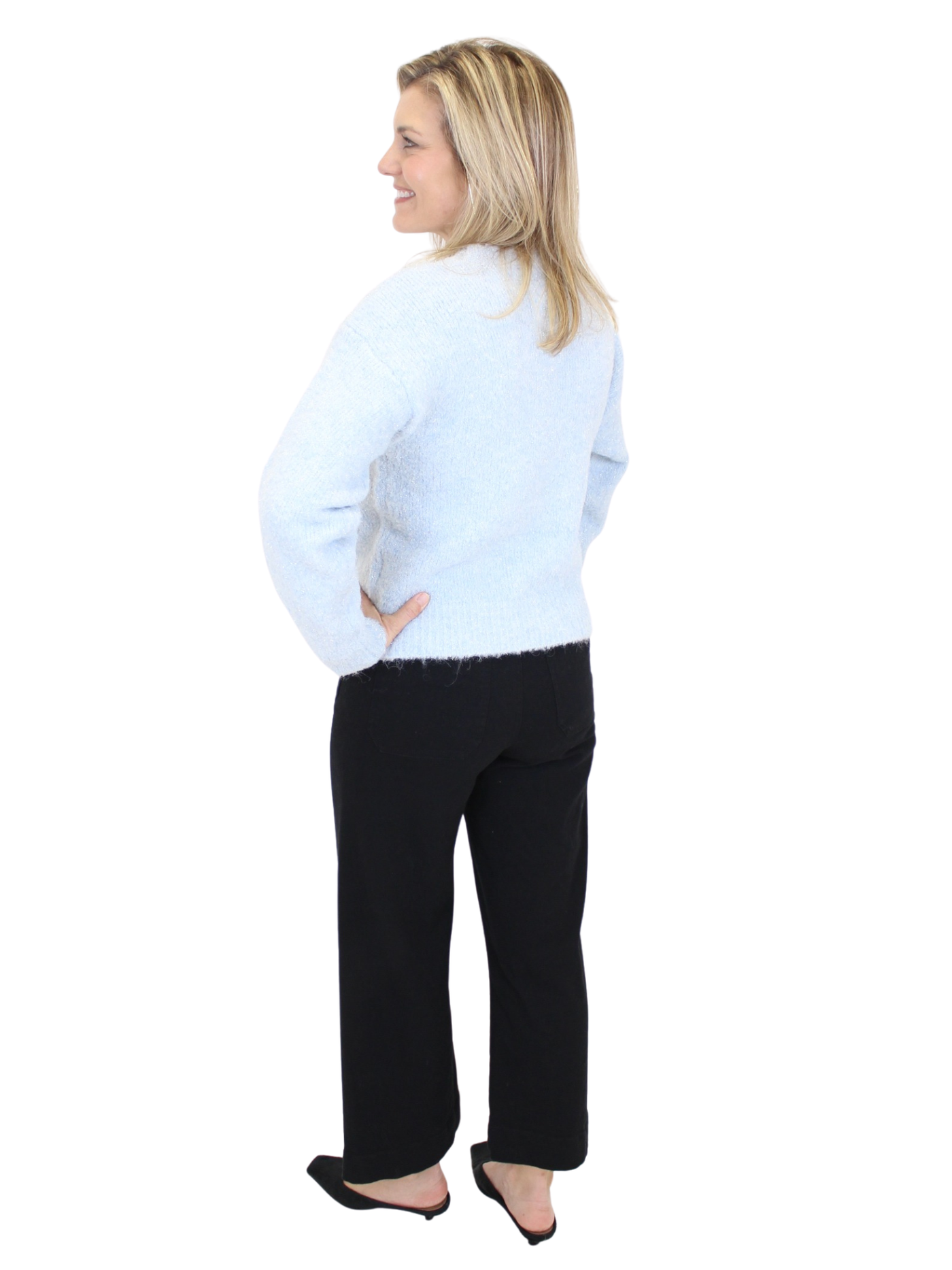 Woman wearing a light blue sweater and black pants on a white background
