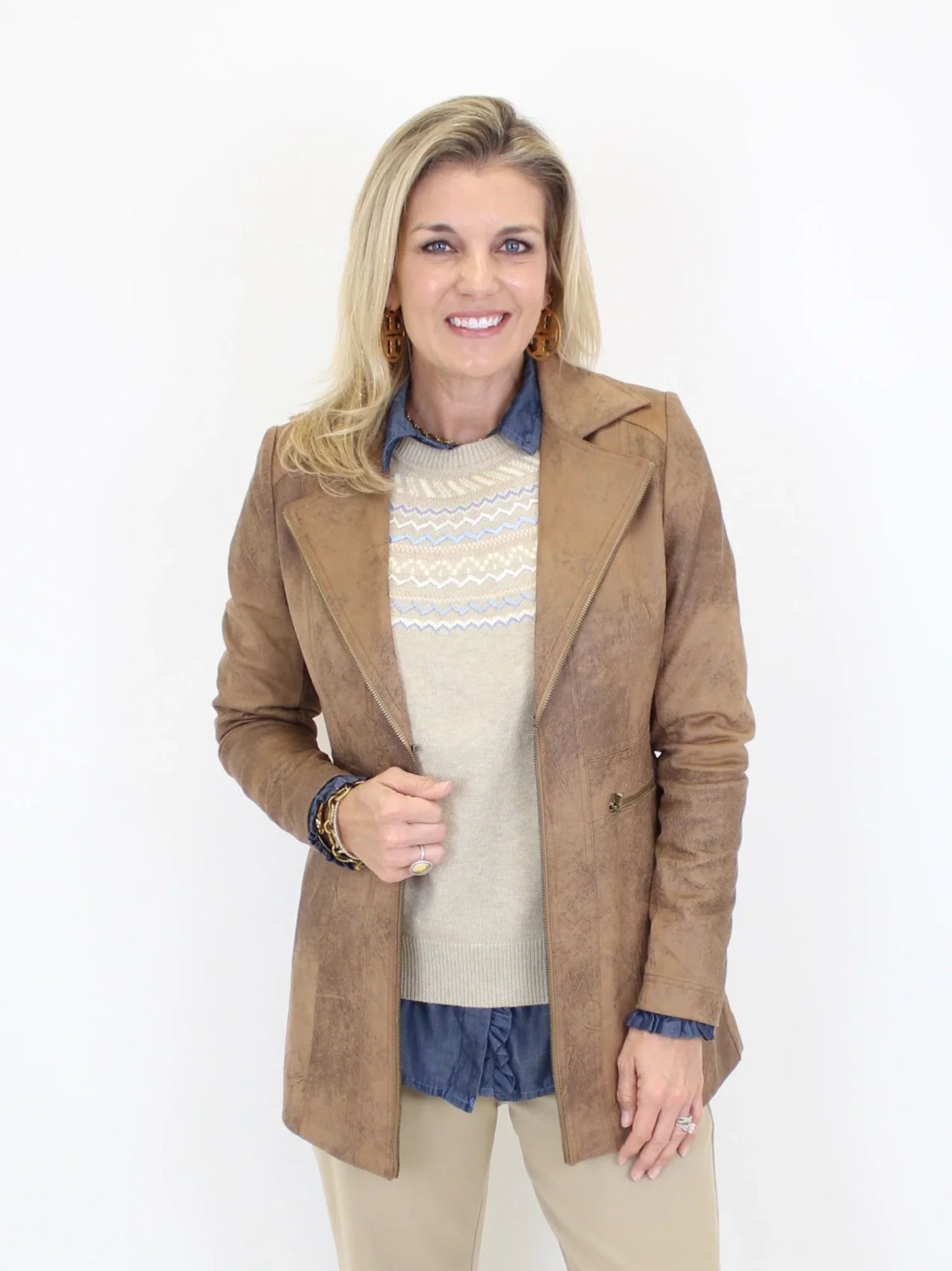 Woman wearing a brown coat over a sweater with a white background