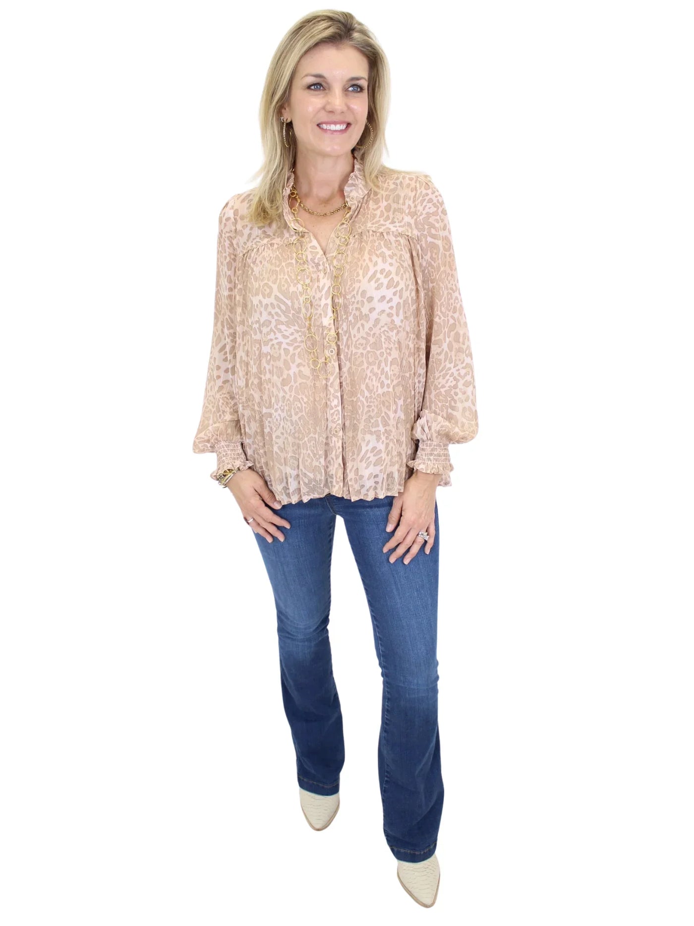 Woman wearing a beige lace blouse and blue jeans on a white background