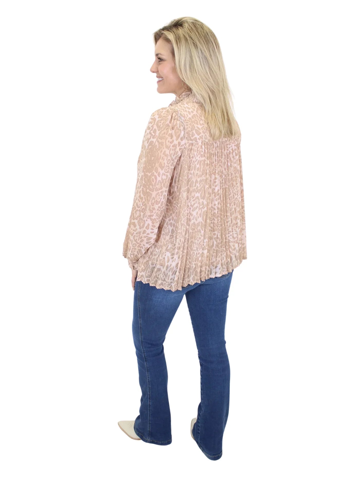 Woman wearing a beige leopard blouse and blue jeans on a white background