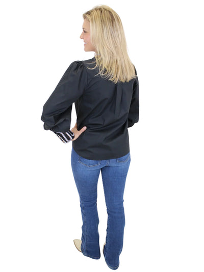 Woman wearing a black blouse and blue jeans on a white background