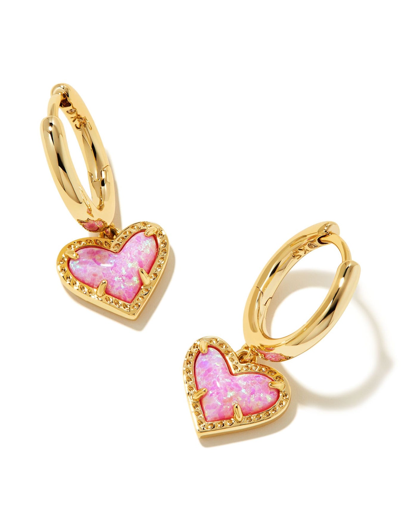Kendra Scott Ari Heart Huggie Hoops in Gold Pink Kyocera Opal on white background.