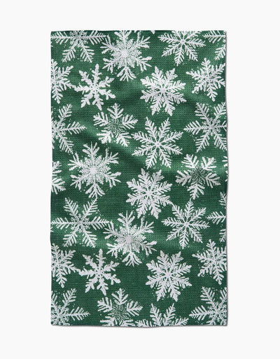 Green tea towel with white snowflake pattern.