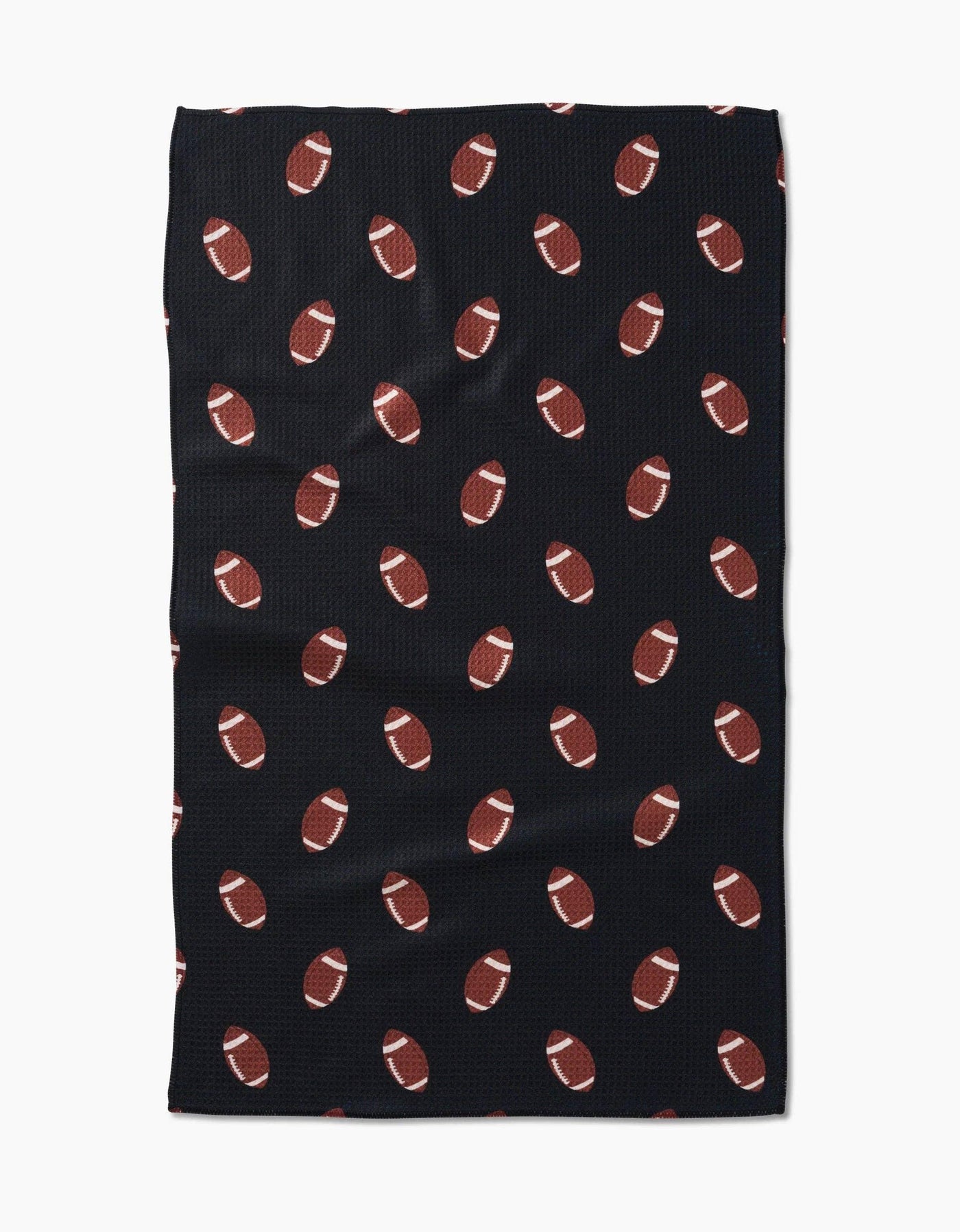 Black tea towel with brown football pattern on a white background.