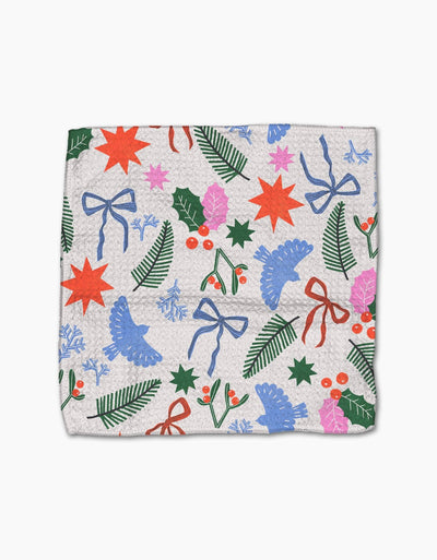Dishcloth with festive pattern featuring stars, bows, and holly on a white background