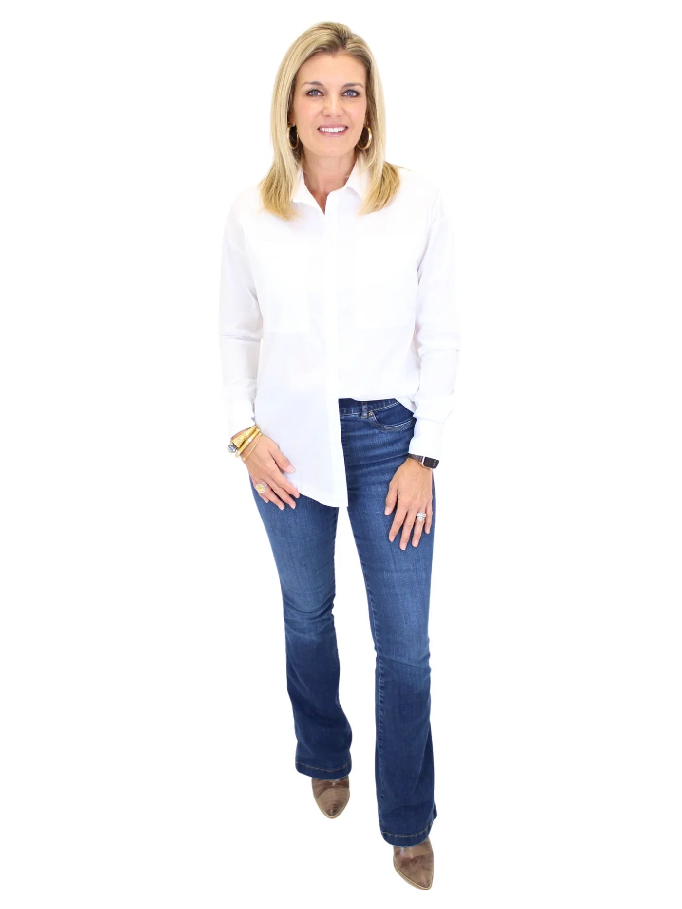 Woman wearing a white blouse and blue jeans on a white background, front.