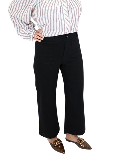 Woman wearing a striped shirt and black pants on a white background, closeup front.