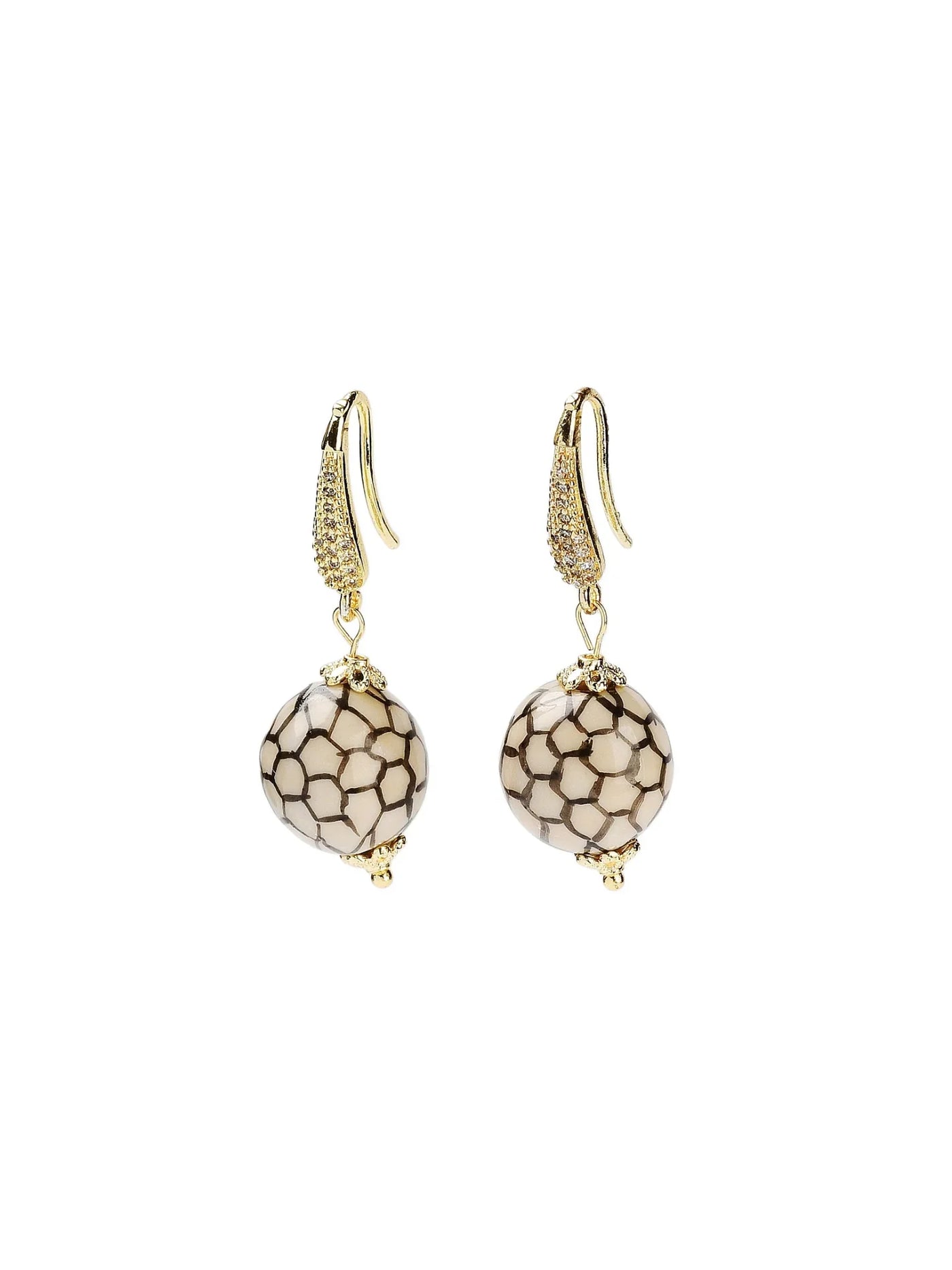 Pair of gold earrings with black and white patterned beads on a white background.