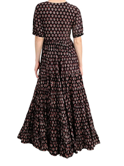 Model wearing brown floral printed maxi dress on white background, back.