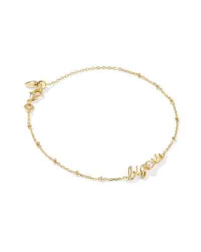 Gold bracelet with big sis pendant and pearl on a white background.