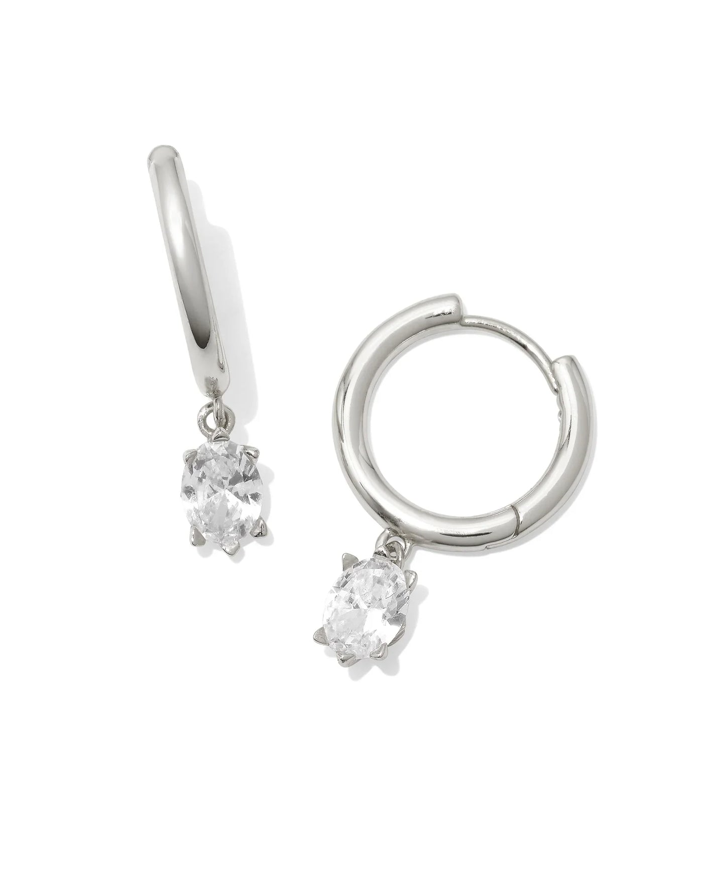 Silver hoop earrings with clear gemstones on a white background.