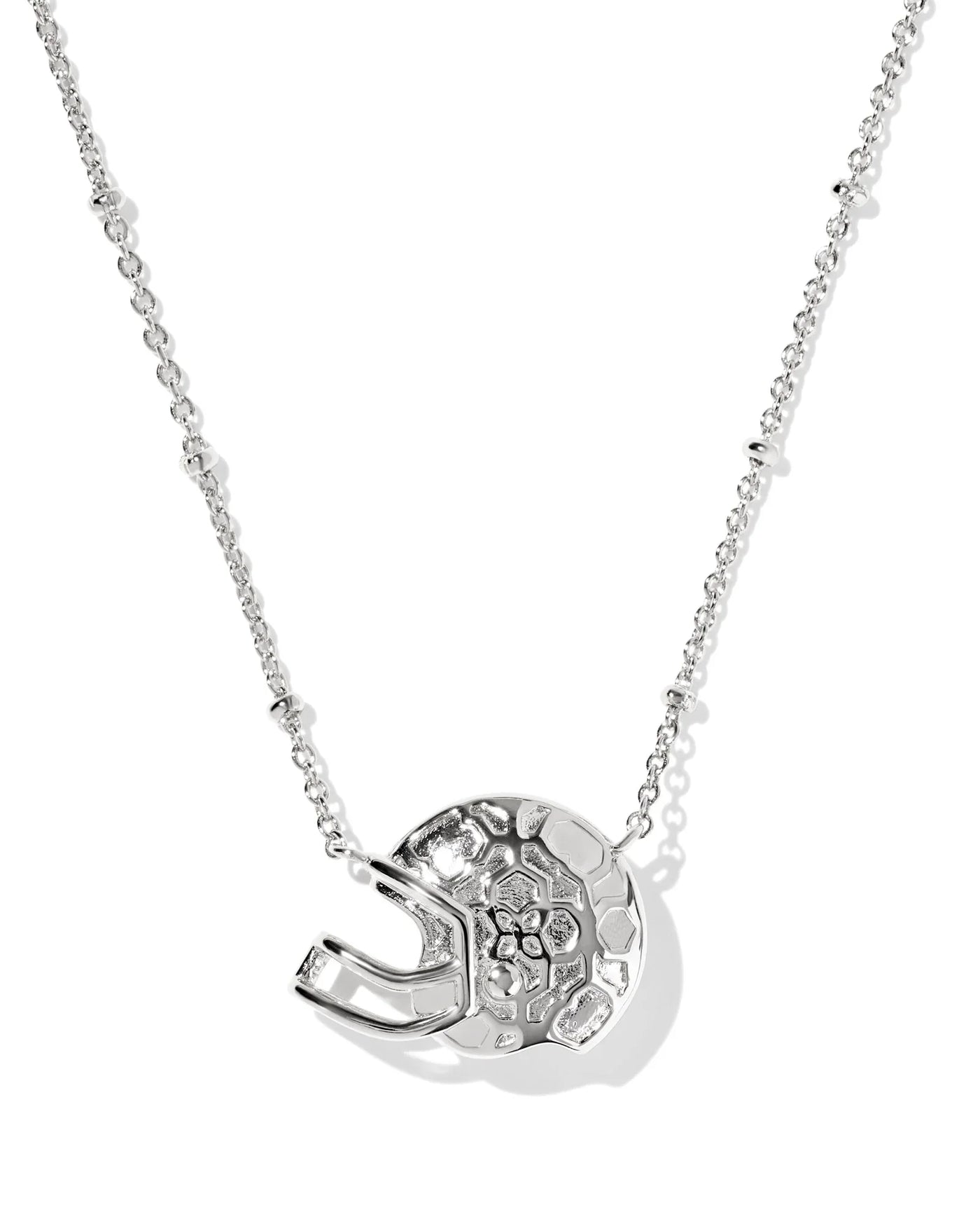 Silver necklace with a football helmet pendant from the back on a white background, closeup.