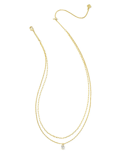 Gold multi strand necklace with crystal pendant on white background.