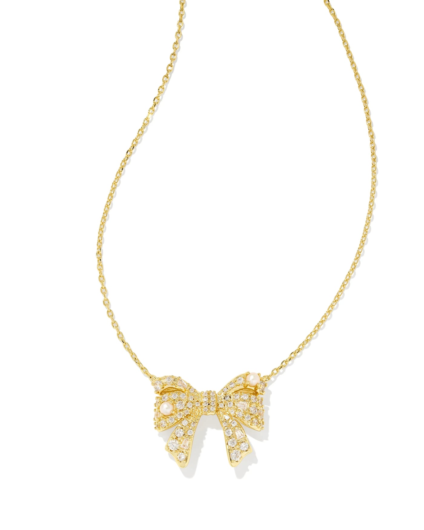 Gold necklace with bow pendant on white background.