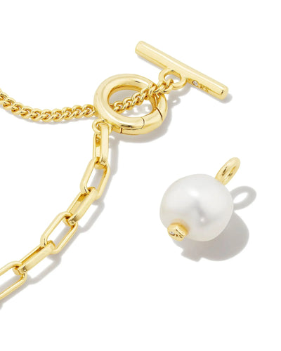 Gold chain necklace with detached pearl pendant on a white background.