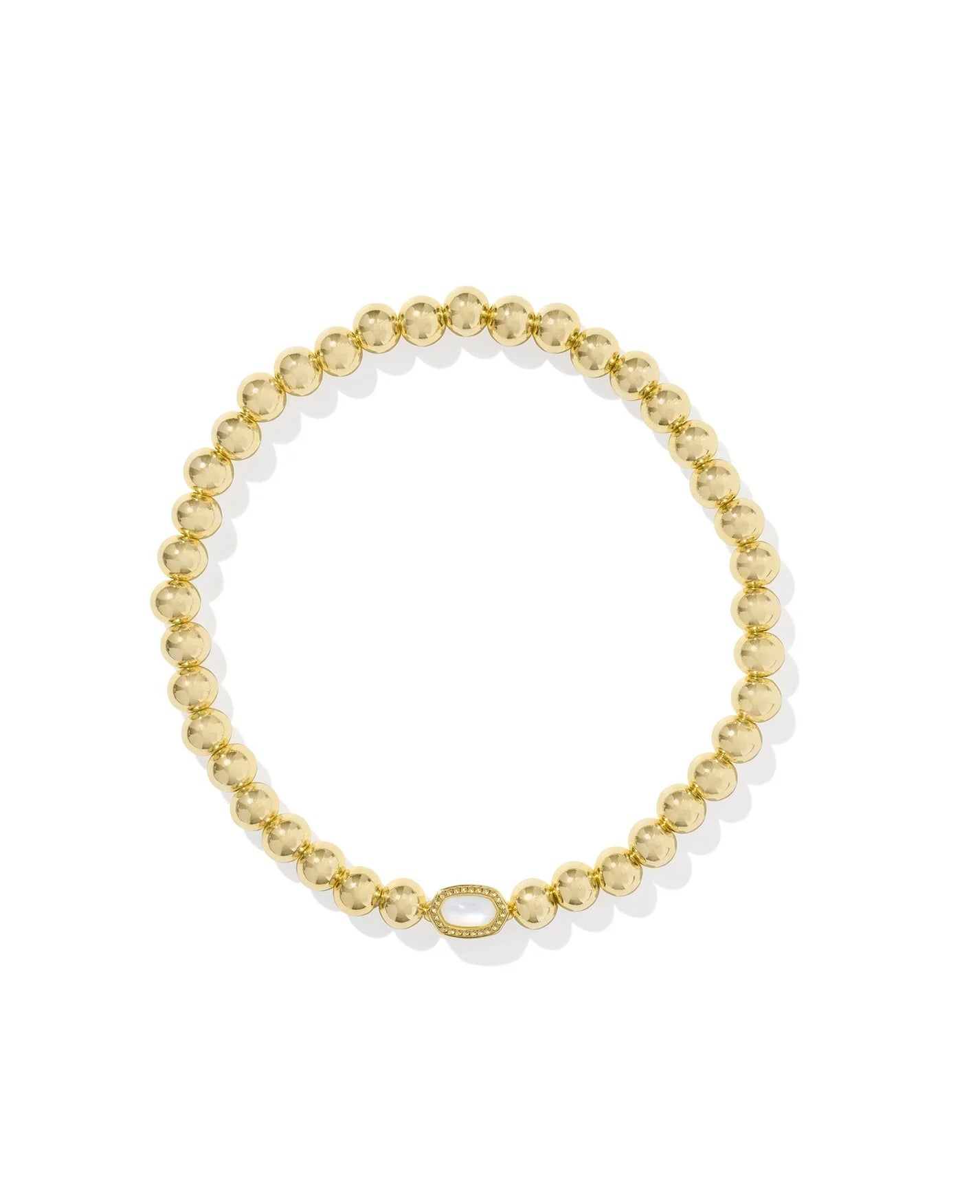 Gold beaded bracelet with mother of pearl center stone on white background.
