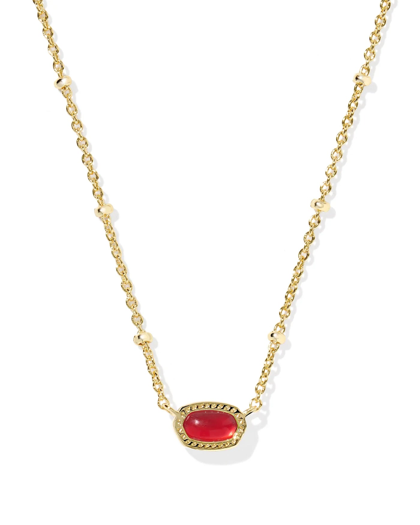 Gold necklace with a red gemstone on a white background, closeup.