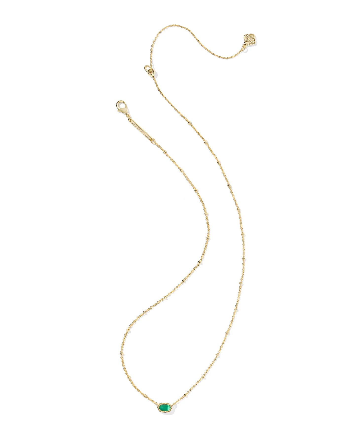 Gold necklace with a green gemstone on a white background