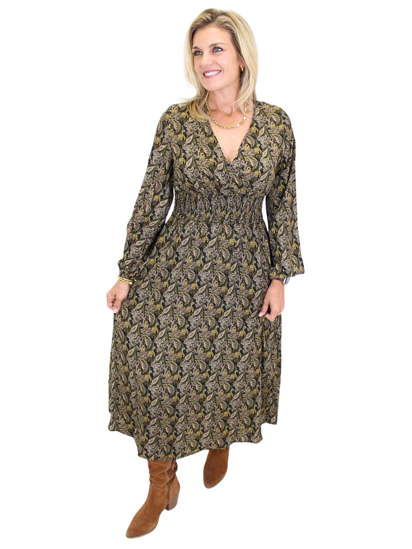 Woman wearing a long sleeve dark color paisley midi dress on white background, front angled.