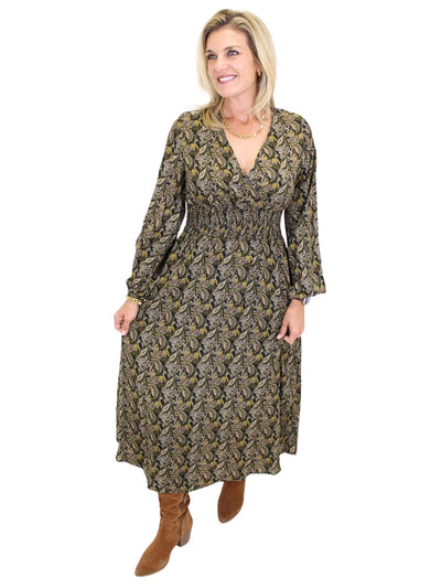 Woman wearing a long sleeve dark color paisley midi dress on white background, front angled.