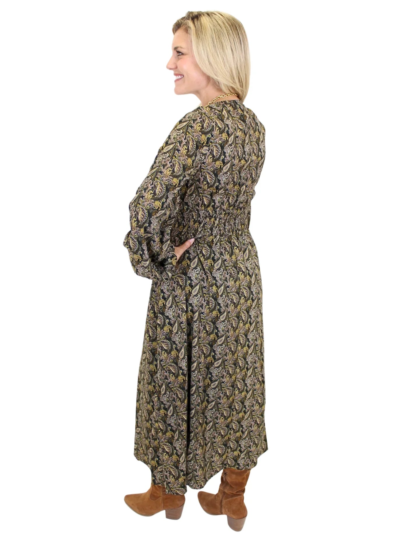 Woman wearing a long sleeve dark color paisley midi dress on white background, back.