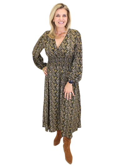 Woman wearing a long sleeve dark color paisley midi dress on white background, front.
