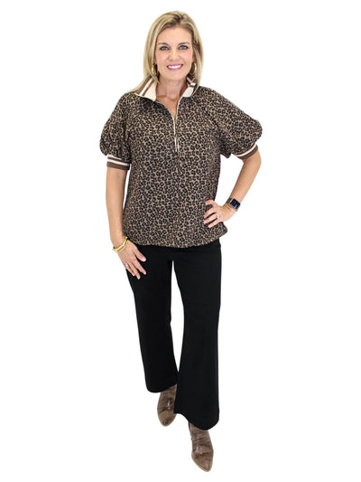 Woman wearing a leopard print shirt with striped collar and cuffs on a white background, front.