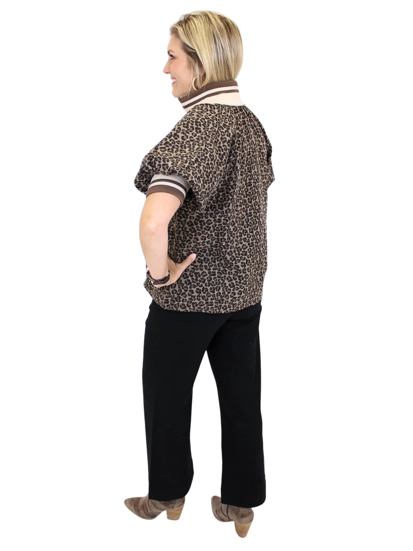 Woman wearing a leopard print shirt with striped collar and cuffs on a white background, back.