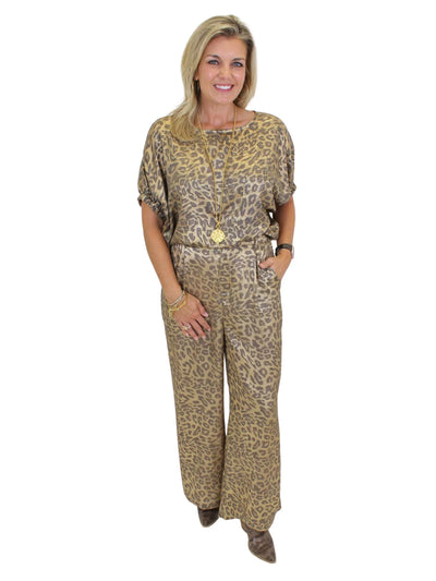 Model wearing tucked metallic leopard print top with hand in side pocket on white background, front.