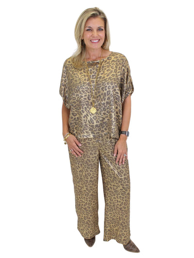 Model wearing untucked metallic leopard print top on white background, front.