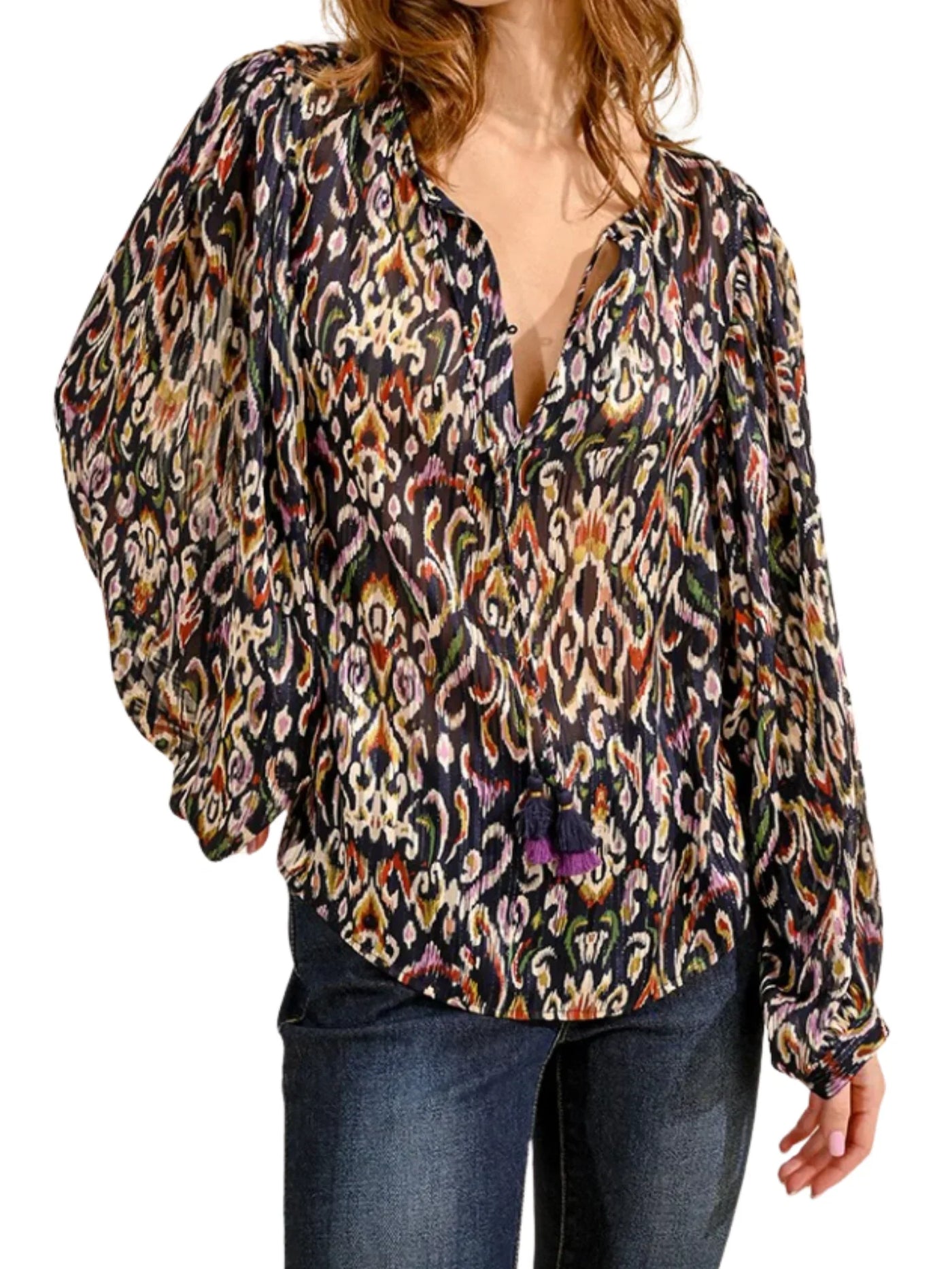 Model wearing multicolored ikat patterned blouse on a white background, front