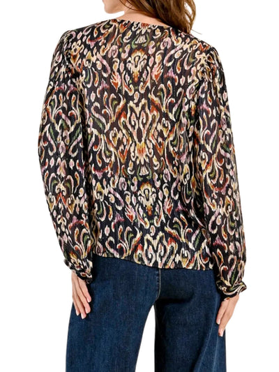 Model wearing multicolored ikat patterned blouse on a white background, back