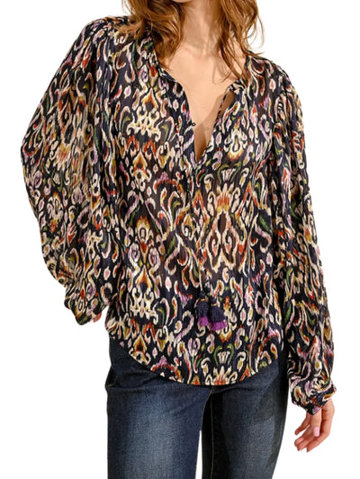 Model wearing multicolored ikat patterned blouse on a white background, front