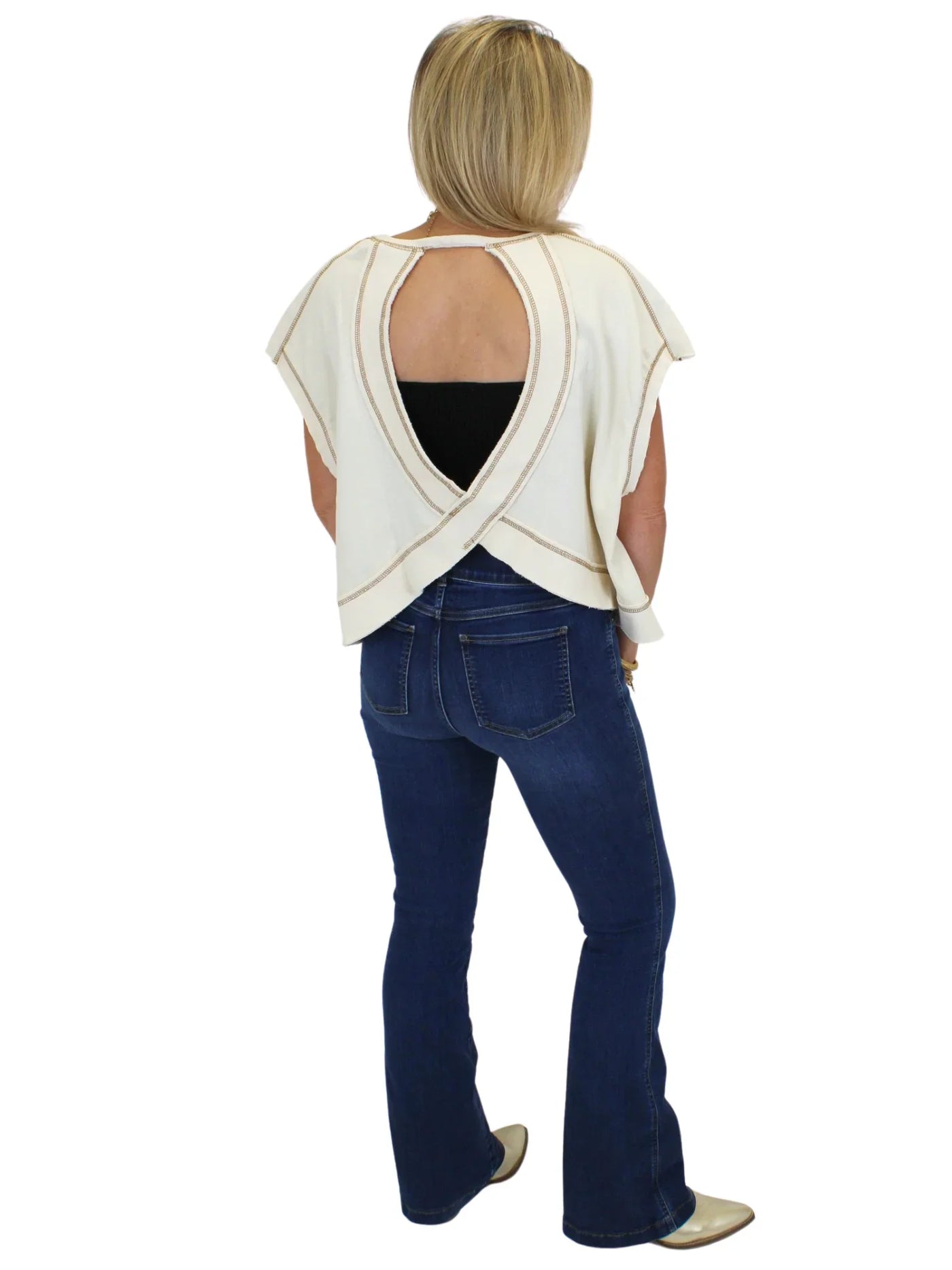 Model wearing cheetah print peace sign top with jeans on white background, back.