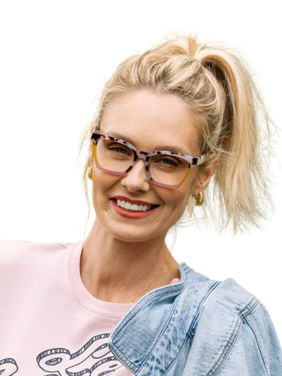 Woman wearing colorful tortoiseshell glasses with a white background.