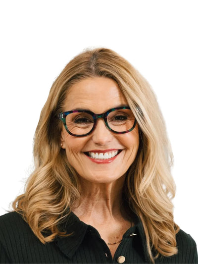 Woman wearing multicolored tortoiseshell glasses on white background.