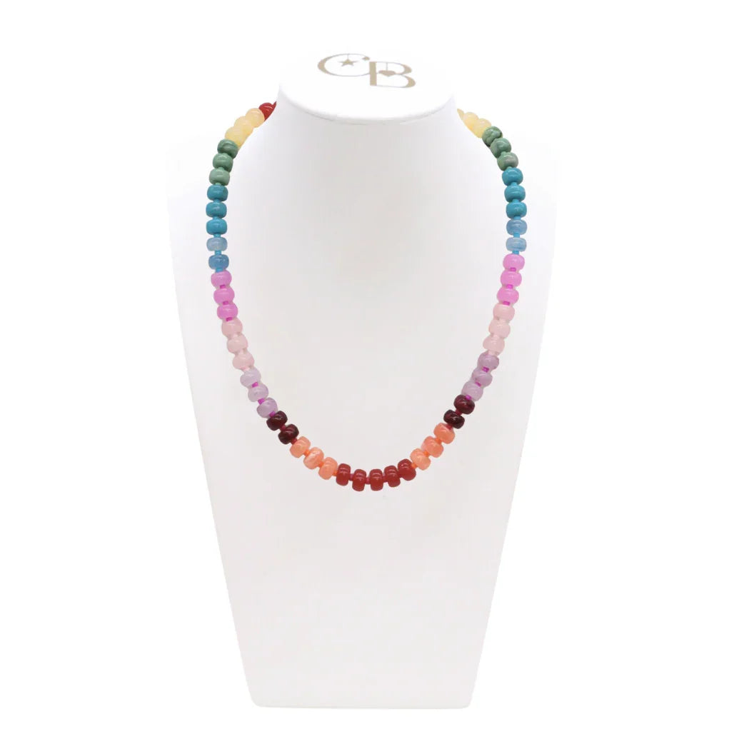 Multicolored beaded necklace on a white stand with a visible brand logo.