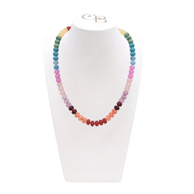 Multicolored beaded necklace on a white stand with a visible brand logo.