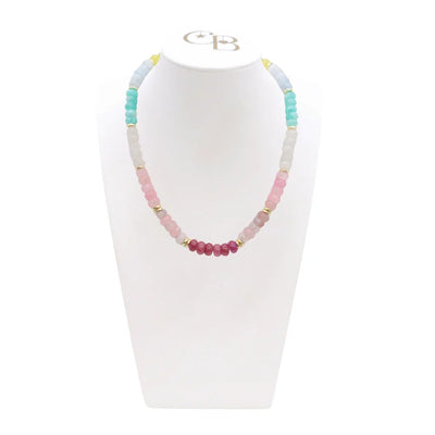 Necklace with multicolored beads on a white stand with a visible brand logo.
