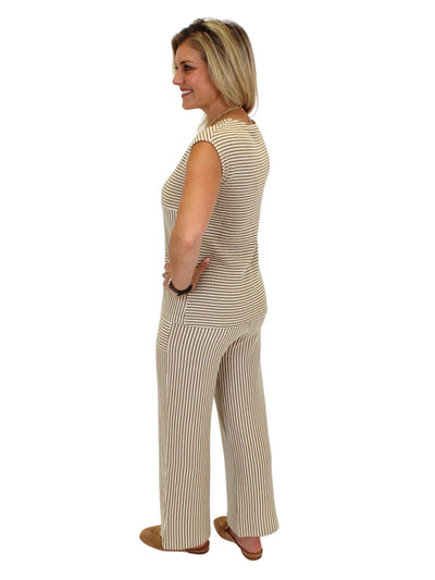 Model wearing brown and white striped knit set on white background, back.