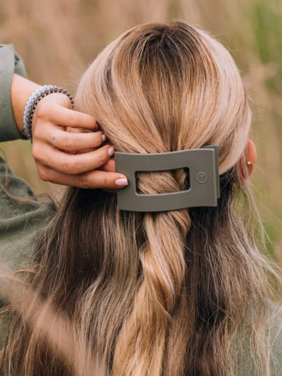 Sage green rectangle hair clip in woman's hair.